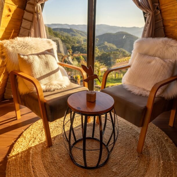 A cozy interior with chairs overlooking a scenic landscape, suggesting family-friendly resorts with comfortable accommodations.