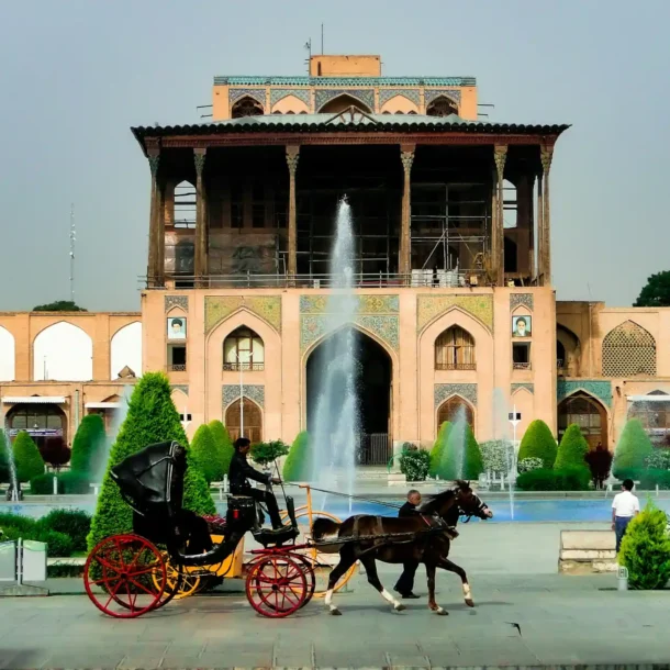 A grand palace with fountains and a horse-drawn carriage in a beautiful garden, symbolizing the luxury and scenic beauty of Staycations at Resorts.