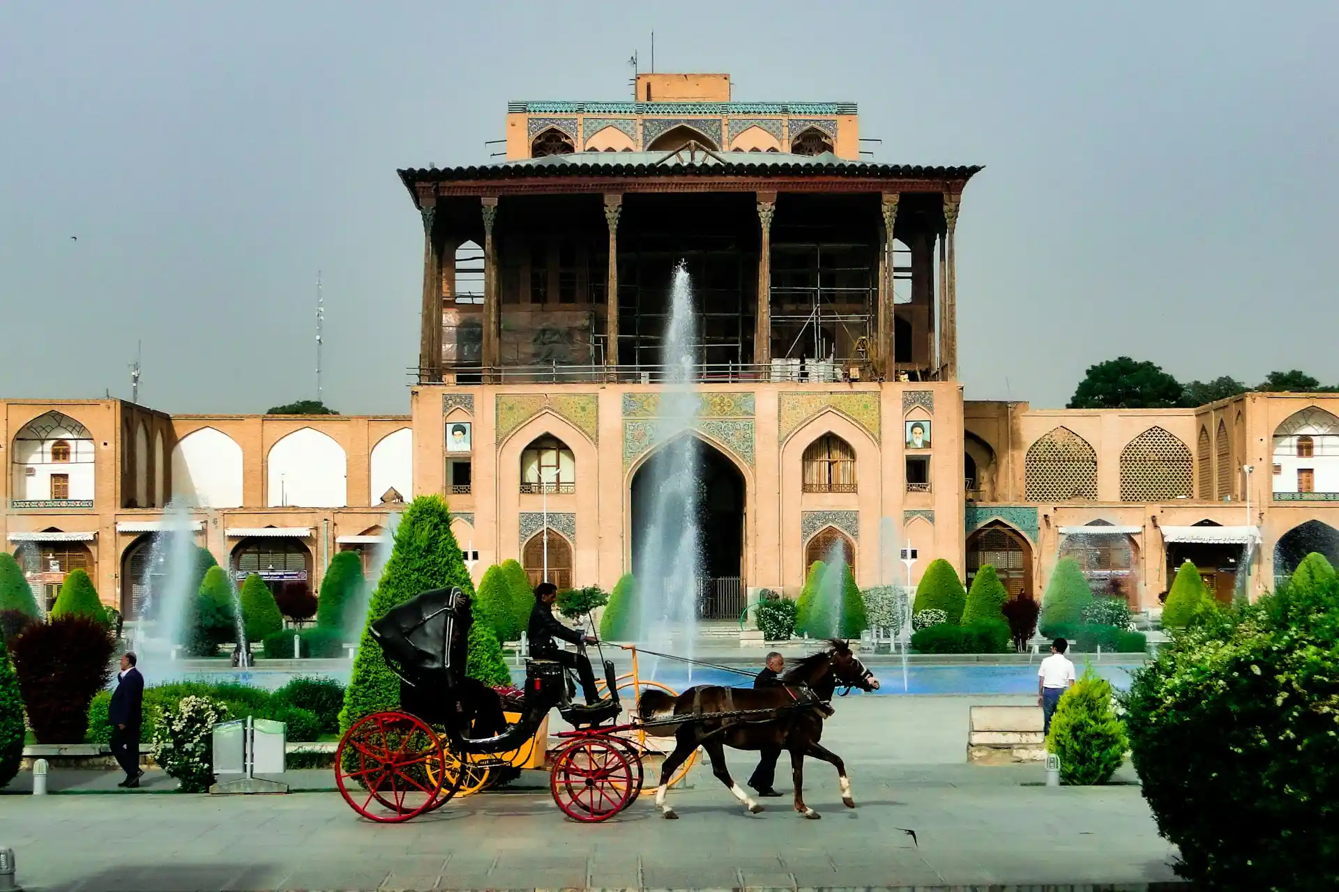 A grand palace with fountains and a horse-drawn carriage in a beautiful garden, symbolizing the luxury and scenic beauty of Staycations at Resorts.